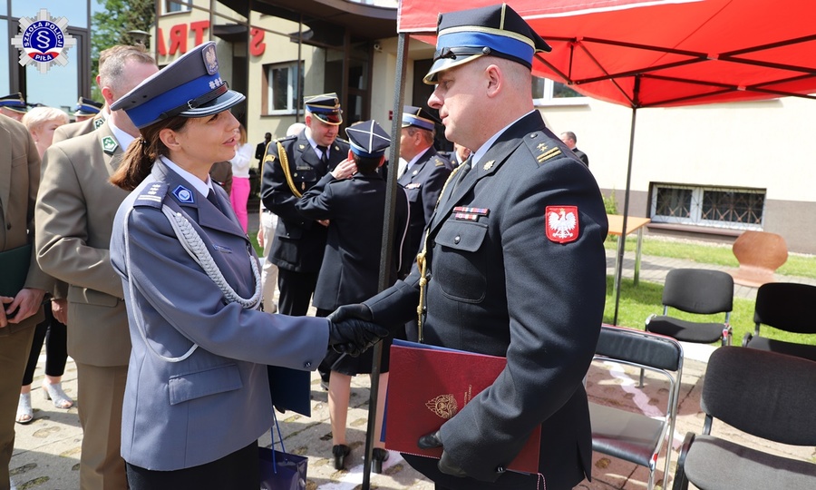 Zastępca Komendanta Szkoły Policji w Pile składa gratulacje oficerowi Państwowej Straży Pożarnej.