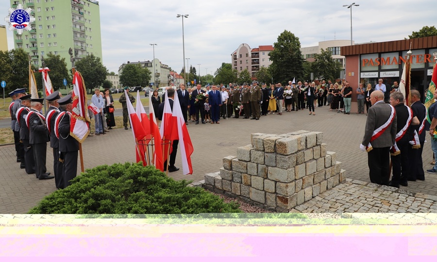 Umundurowani funkcjonariusze i osoby cywilne składający na stojąco hołd pod pomnikiem