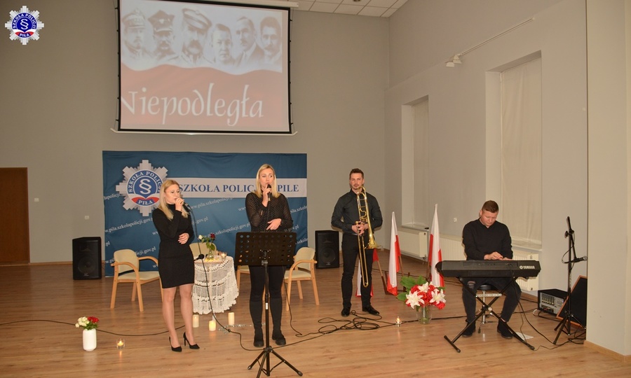 Cztery osoby na scenie, dwie kobiety śpiewając, dwóch mężczyzn gra na instrumentach.