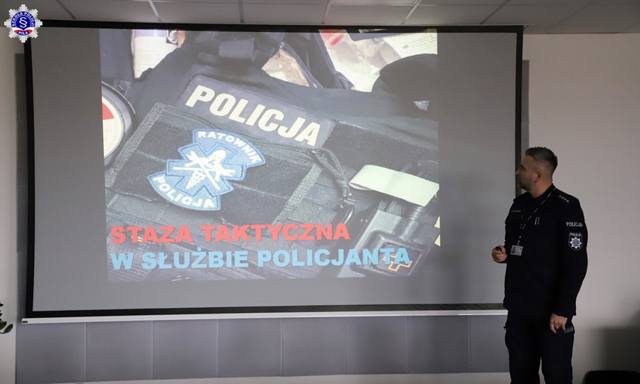 Umundurowany nadkom. Marcin Kolasiński prezentujący tytuł swojego wystąpienia zajęć fakultatywnych dla słuchaczy Szkoły Policji w Pile