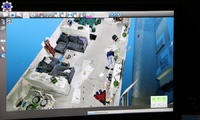 Zbliżenie na ekran skanera 3D, na którym widać człowieka leżącego na podłodze w mieszkaniu