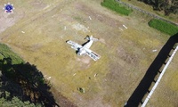 Zdjęcie z drona widok na byłą strzelnicę garnizonową, widoczna oś strzelecka na środku której stoi samolot.