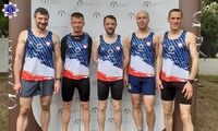 Grupa pięciu mężczyzn w strojach sportowych po zakończonym biegu na wspólnej fotografii