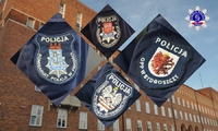 Emblematy jednostek organizacyjnych Policji na tle budynku głównego Szkoły Policji w Pile