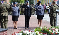 Przedstawiciele delegacji służb mundurowych oddający honory pod pomnikiem.