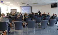 Grupa osób siedząca na sali podczas wykładu.