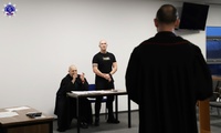 Oskarżony, obrońca i prokurator ubrany w strój koloru czarnego z czerwoną oblamówką