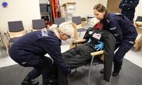 Słuchacze realizują ćwiczenia praktyczne w zakresie udzielenia pierwszej pomocy.