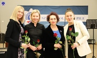Stojąca Pani Komendant w otoczeniu trzech kobiet z wręczonymi różami.