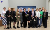 Pani Komendant stojąca na środku, w towarzystwie jedenastu kobiet. Wszystkie trzymają w ręku różę.